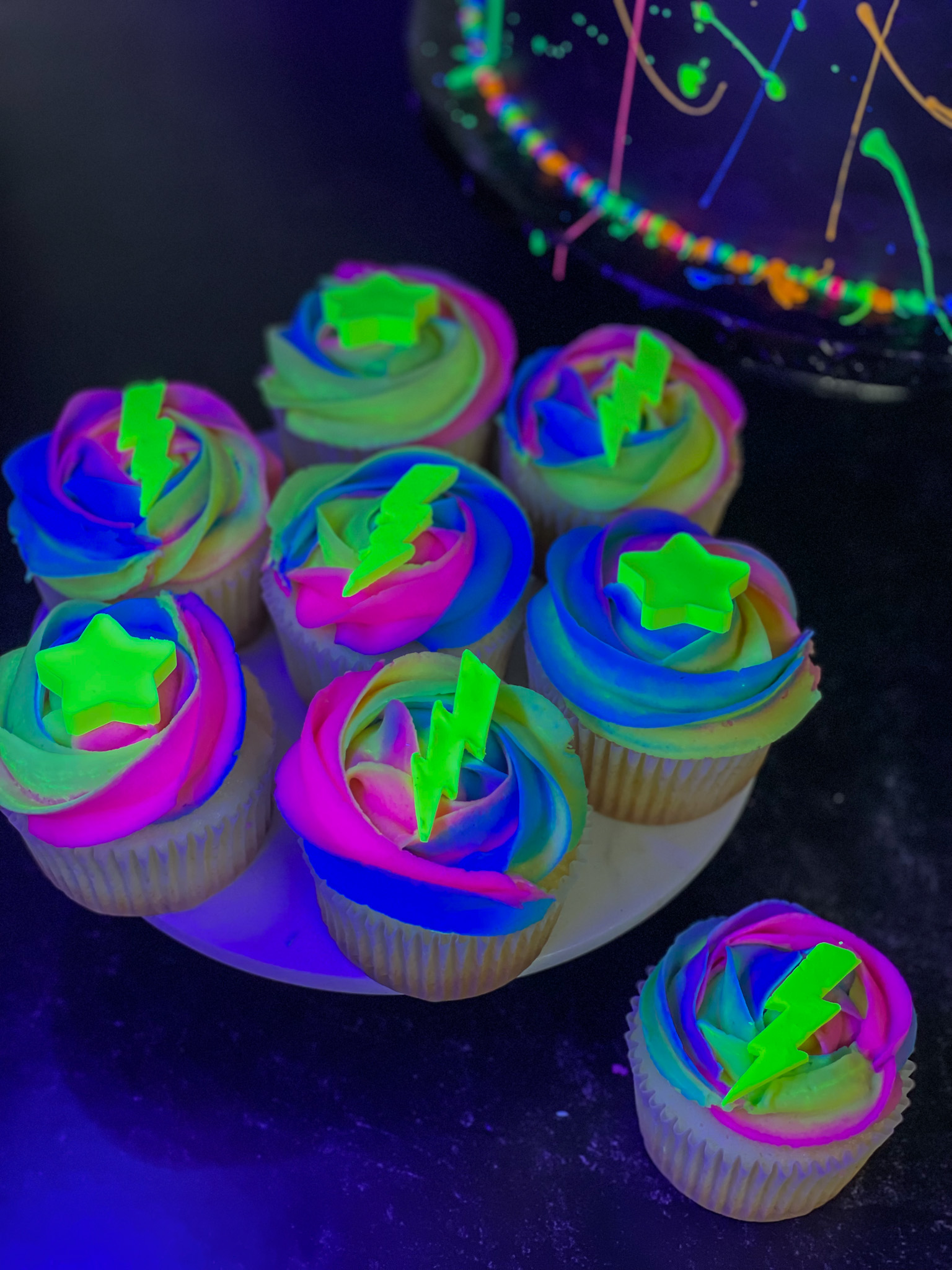 Neon blacklight cupcakes for kids glow party with colorful swirled frosting
