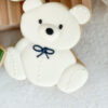 cream teddy bear with navy blue bow