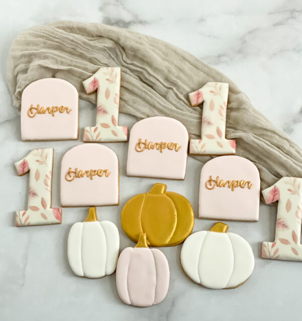 Personalized lil pumpkin first birthday cookies Custom fall first birthday sugar cookies decorated with pumpkins, autumn leaves, gold details, and personalized birthday cookies in soft blush, white, and warm fall colors.