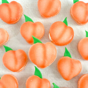 peach shaped macarons with an edible green leaf